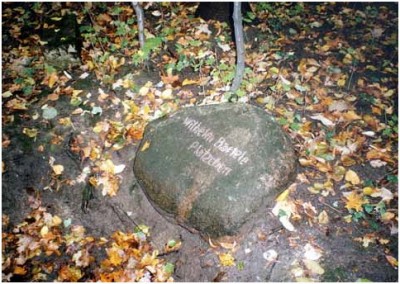 валунный камень с надписью: &quot;Площадка Вильгельма Бартеле&quot;, рядом со столбом-указателем в Макс Ашман парке